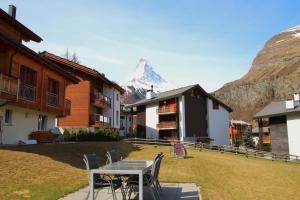 einen Tisch und Stühle vor einem Berg in der Unterkunft Zanana in Zermatt