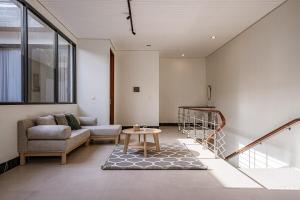 a living room with a couch and a table at Brand New 2BR Villa Alpha Omega Canggu Bali in Mantaak