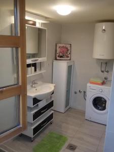 a bathroom with a sink and a washing machine at Villa Magnolia in Radanovići