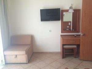 オルデニズにあるVilla Beldenizの椅子、デスク、テレビが備わる客室です。