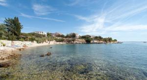 a beach with people and animals in the water at Apartment Ruby in Mandre