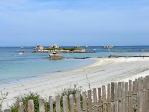 una spiaggia con recinzione in legno e l'oceano di Le Spa sur la dune, Santec, Bretagne a Santec