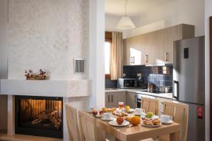 a kitchen with a table with food and a fireplace at Oikos- "Your Cretan House" in Angeliana