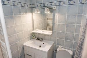 une salle de bain avec un lavabo, des toilettes et un miroir dans l'établissement Grau du Roi - Los Amigos II, au Grau-du-Roi