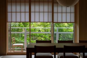 a dining room with a table and a large window at プライベートリゾート仙居 in Hakone