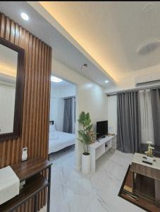 ein Wohnzimmer mit einem Zimmer mit einem Bett und einem TV in der Unterkunft Modern Minimalist 1BR Condotel at BGC Taguig in Taguig
