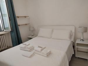 a white bed with two towels on top of it at desideri 2 affittacamere in Numana