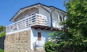 a house with a balcony on the side of it at Casutadinvama in Vama Veche