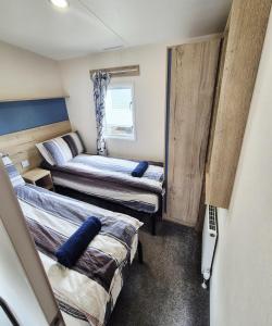 a small room with two beds in it at New 2 bed holiday home with decking in Rockley Park Dorset near the sea in Lytchett Minster