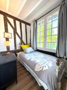 a bedroom with a bed and a window at Le Manoir familial du Quesnot, idéal familles et amis in Lessard-et-le-Chêne