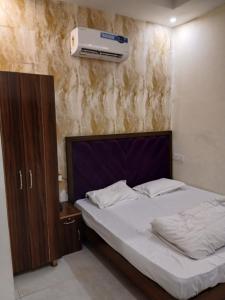 齐拉克普尔Hotel Golden Rooftop的卧室配有一张床,墙上配有空调 更多10张照片