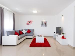 a white living room with a couch and a tv at Apartment Bingo in Trogir