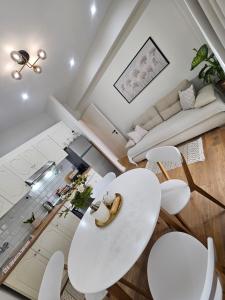a white living room with a white table and chairs at Eda house in Gouvia