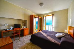 Schlafzimmer mit einem Bett, einem Schreibtisch und einem TV in der Unterkunft Crotto Di Gittana in Perledo