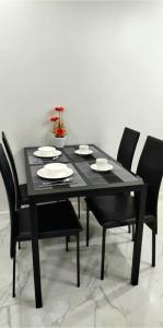 ein schwarzer Esstisch mit schwarzen Stühlen und einer schwarzen Tisch- und Stuhlplatte in der Unterkunft Modern Minimalist 1BR Condotel at BGC Taguig in Taguig