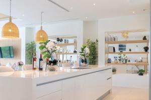 a kitchen with white cabinets and a counter with flowers at The Exclusive Sky D4 豪华4卧室海景别墅 私人12m无边海景泳池 每日清洁 in Kamala Beach