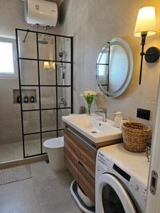 a bathroom with a washing machine and a sink at Eda house in Gouvia