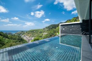a swimming pool with a view of the ocean at The Exclusive Sky D4 豪华4卧室海景别墅 私人12m无边海景泳池 每日清洁 in Kamala Beach