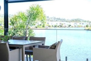 a table and chairs with a view of the water at Waterfront Stay at Sunshine Villa in Maroochydore +59 photos