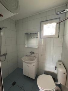 a bathroom with a toilet and a sink and a window at Cozy House with Free parking in Varna City +37 photos