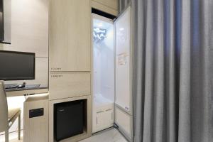 a room with a shower with a tv and a window at Hound Hotel Asan Terminal in Asan