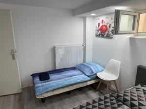 a small bedroom with a bed and a white chair at Rose in Günzburg +14 photos