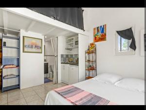 a white bedroom with a bed and a kitchen at Chez Chris in Fréjus +1 photo