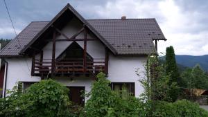 a white house with a brown roof at Olko House in Yaremche
