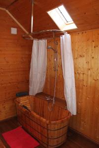 eine Holzbadewanne mit Dusche im Zimmer in der Unterkunft VALRELEY, chambres et table d'hôtes eco-friendly avec bain nordique au sud du massif du Jura in Champagne-en-Valromey