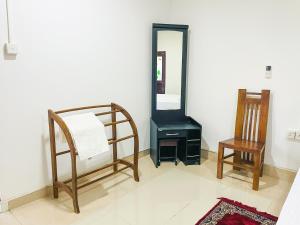 a room with a mirror and a bed and a chair at Sun & Queen Villa in Dambulla