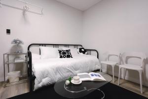 a bedroom with a bed with a table and chairs at Hotel INSAENG Bucheon in Bucheon