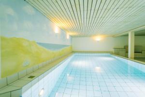 a large swimming pool with a painting on the ceiling at Gemütliche Wohnung Reet-Pool-Sauna in Keitum