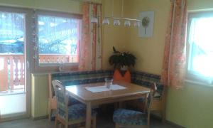 a dining room with a table and chairs and windows at Haus Sagl in Nauders