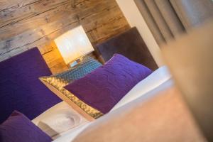 an overhead view of a bed with purple pillows at Hotel Talblick in Saalbach-Hinterglemm