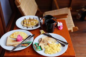 zwei Teller mit Frühstücksspeisen auf einem Holztisch in der Unterkunft Belangga Cottage in Nusa Penida + 25 Fotos