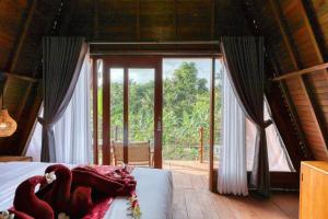 Schlafzimmer mit einem Bett und einer großen Glastür in der Unterkunft Belangga Cottage in Nusa Penida