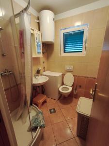 ein kleines Badezimmer mit Toilette und Waschbecken in der Unterkunft Villa Veronika in Brodarica