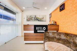 a hotel room with a couch and a wall at Hotel O Ahmedabad Airport in Ahmedabad