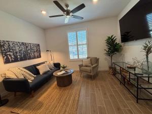 Una sala de estar con un sofá y un ventilador de techo. en Joyhouse, en Visalia