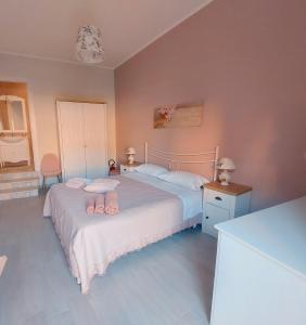 two beds in a bedroom with pink walls at affittacamere lu mari lu suli lu ventu in Gela