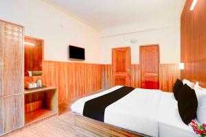 Un dormitorio con una cama y un televisor. en Hotel O Manali Near Hadimba Temple, en Manali 18 fotos más