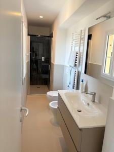 Un baño blanco con inodoro y lavabo. en Blue Residence - Spettacolare casa a Pieve Ligure, en Pieve Ligure