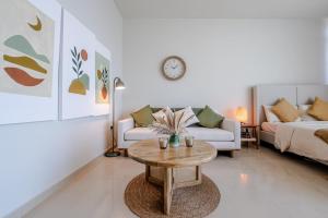 ein Wohnzimmer mit einer Couch und einem Couchtisch in der Unterkunft Boho Chic Studio, Pool & Gym in Abu Dhabi