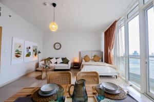 ein Wohnzimmer mit einem Bett und einem Tisch mit Stühlen in der Unterkunft Boho Chic Studio, Pool & Gym in Abu Dhabi