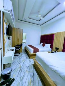 马图拉Premium Hotel Aarav Grand - Mathura Central - 5 Min distance from Railway Station的有两张床和一台电视的酒店房间 更多20张照片