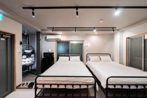 a room with two beds in a room at Sunshine Inn 456 - Economic APT in Tokyo Tranquil Block, with Direct Access to Ginza & Akihabara in Tokyo