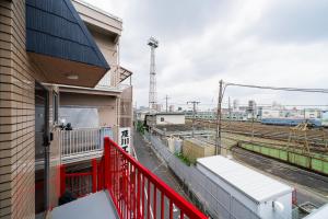 a balcony with a red railing next to a building at Sunshine Inn 456 - Economic APT in Tokyo Tranquil Block, with Direct Access to Ginza & Akihabara in Tokyo +81 photos