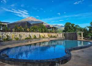 a swimming pool in a resort with a mountain in the background at Asri Rinjani Hotel in Sembalun Lawang
