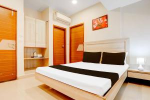 瓜廖尔Hotel O Jiwaji Chowk Lashkar的房间里有一张大床的卧室