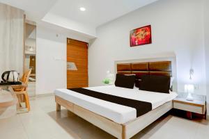 瓜廖尔Hotel O Jiwaji Chowk Lashkar的房间里有一张大床的卧室